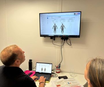 Coach and client reviewing body composition progress results on a computer screen